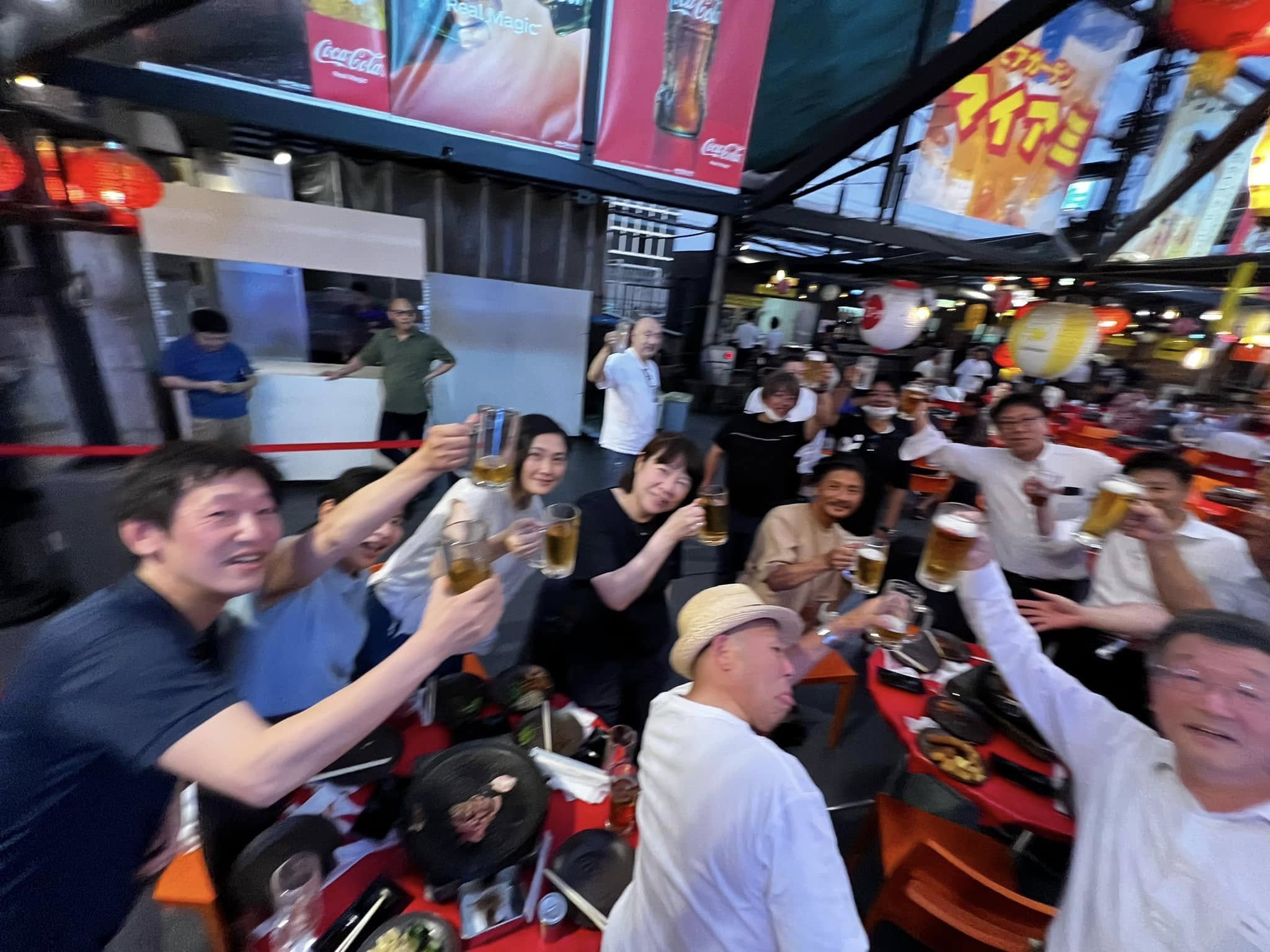 会員がビアガーデンで笑顔で乾杯する親睦行事の様子